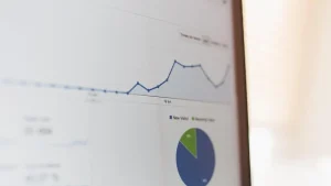 Laptop screen showing a rising line chart and a pie chart in a website analytics report