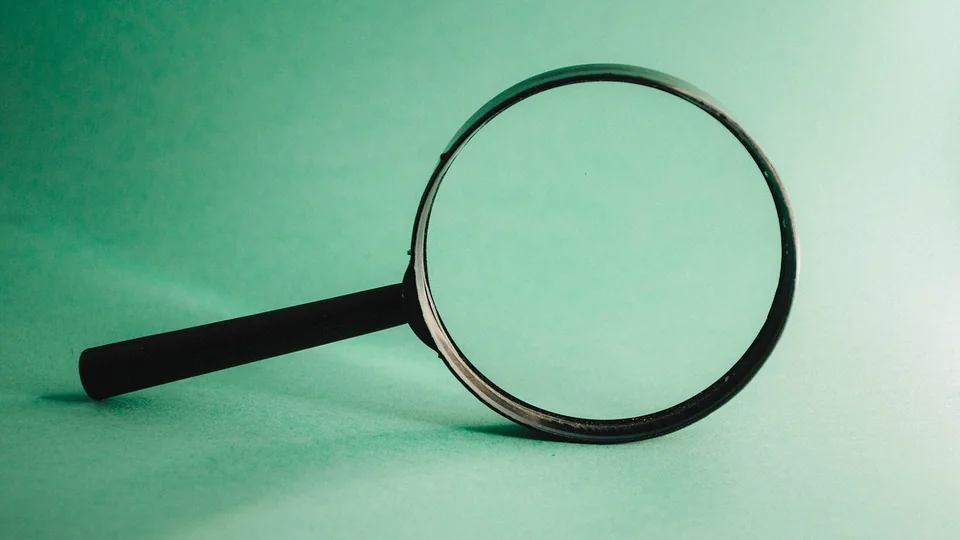 Magnifying glass standing on a green surface