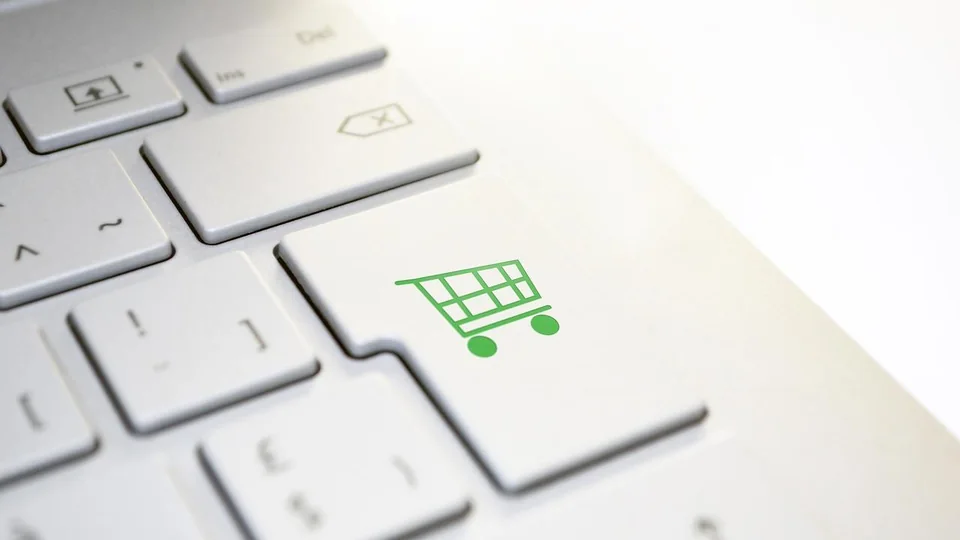 Close-up of a white keyboard with a green shopping cart key for online shopping
